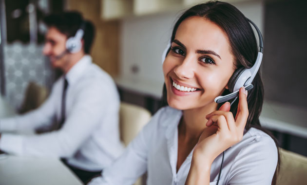 Call center representative wearing a headseat, smiling into the camera